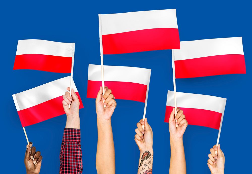 Hands waving the flags of Poland