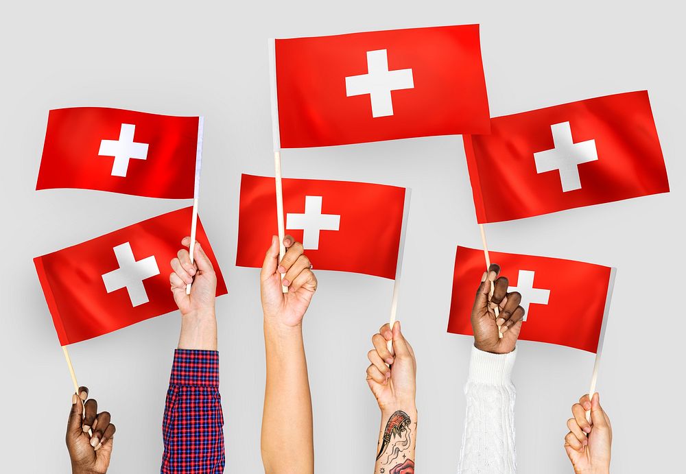 Hands waving the flags of Switzerland