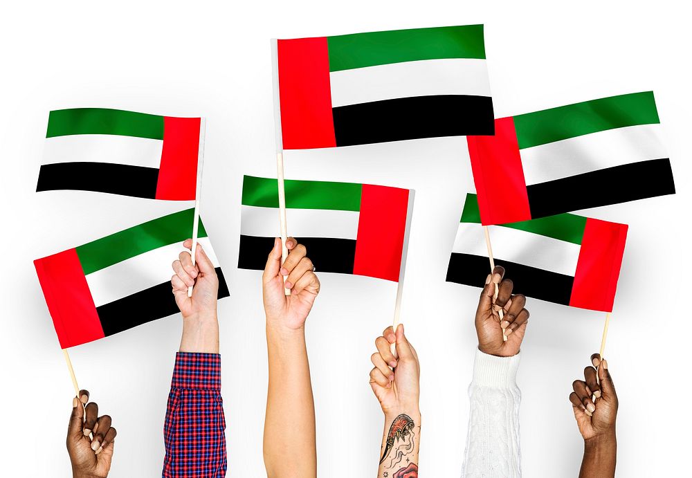 Hands waving flags of the United Arab Emirates