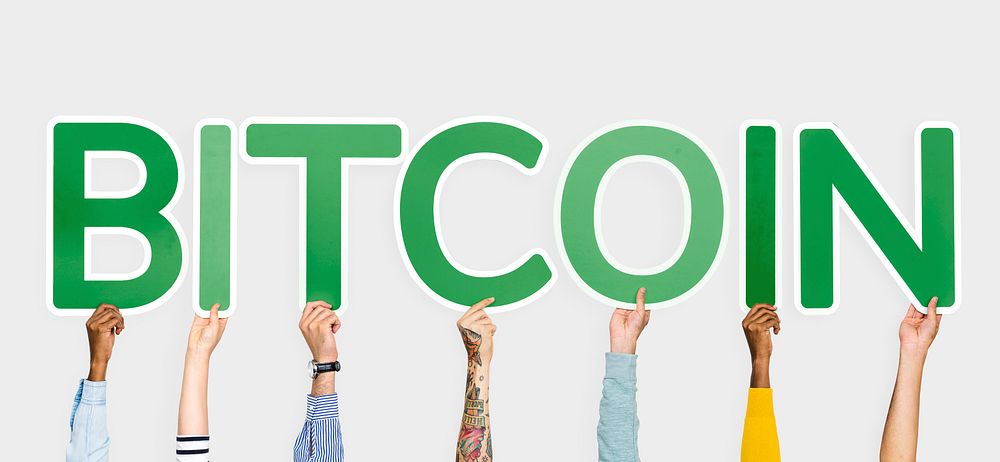 Hands holding up green letters forming the word bitcoin