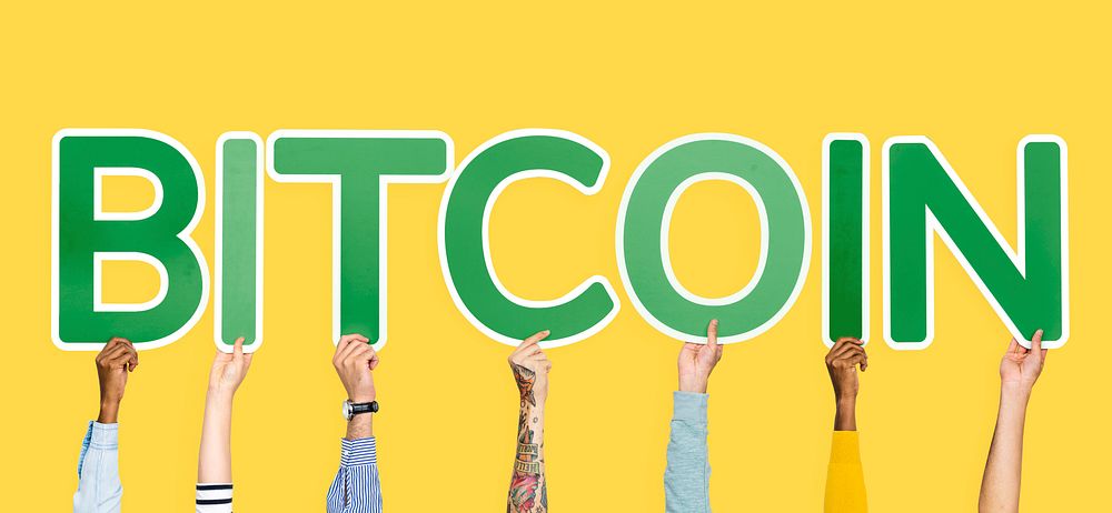 Hands holding up green letters forming the word bitcoin