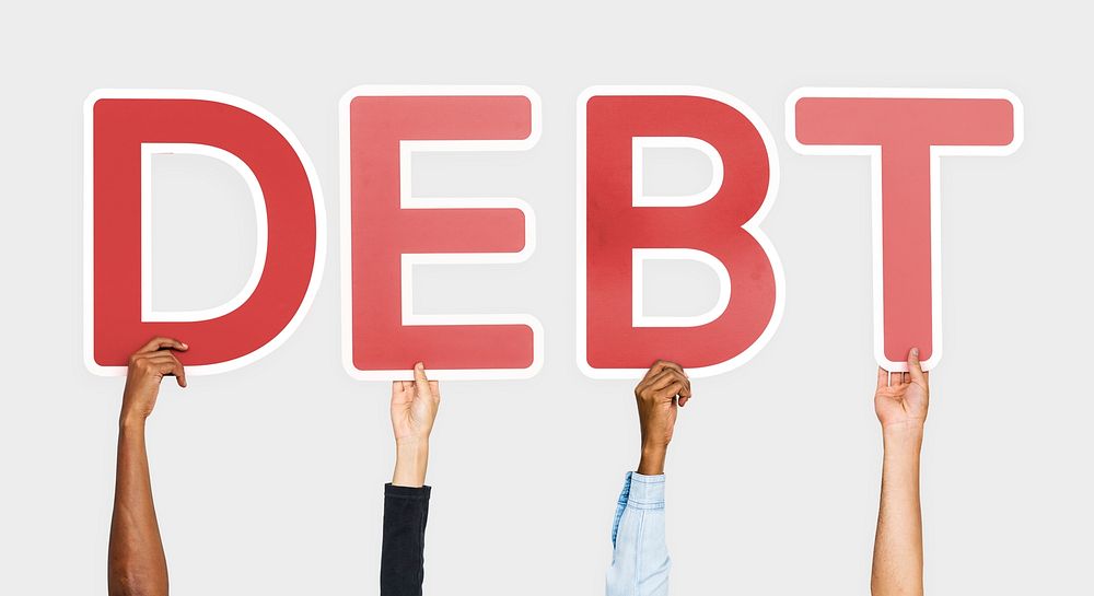 Hands holding up red letters forming the word debt