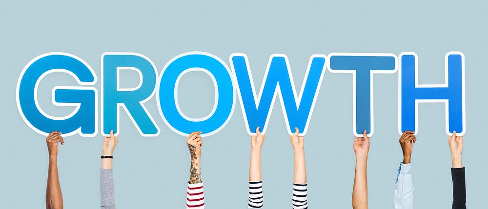 Hands holding up blue letters forming the word growth