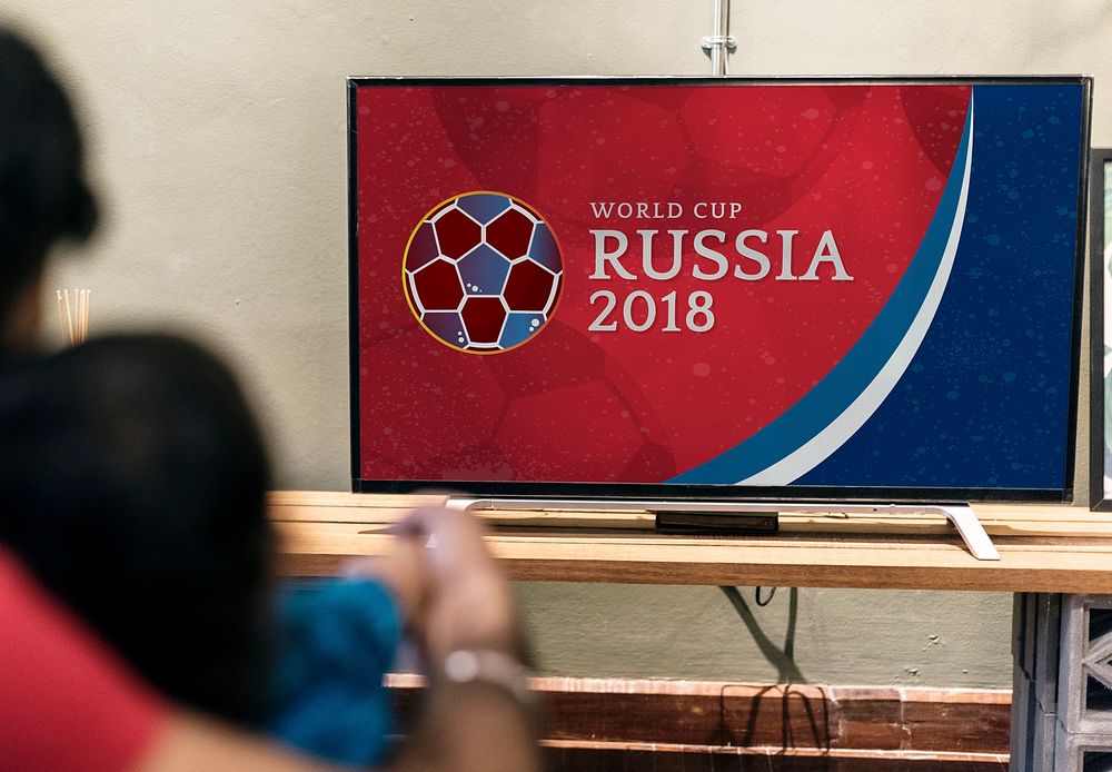 Family watching a football match on the  tv