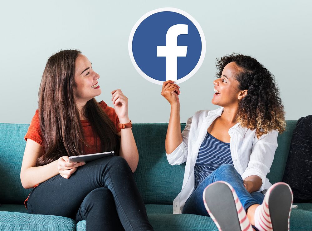 Young women showing a Facebook icon