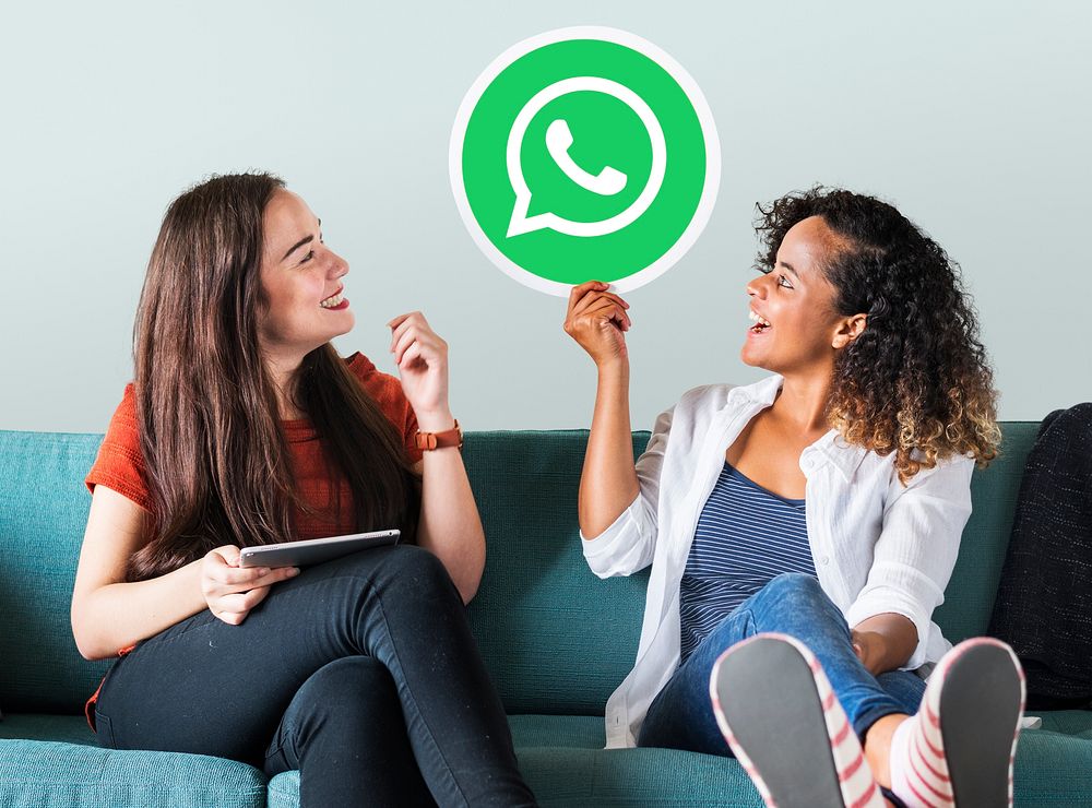 Young women showing a WhatsApp Messenger icon
