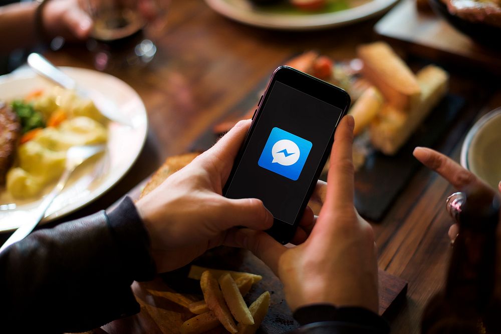 A person using Facebook Messenger in a restaurant. BANGKOK, THAILAND, 1 NOV 2018.