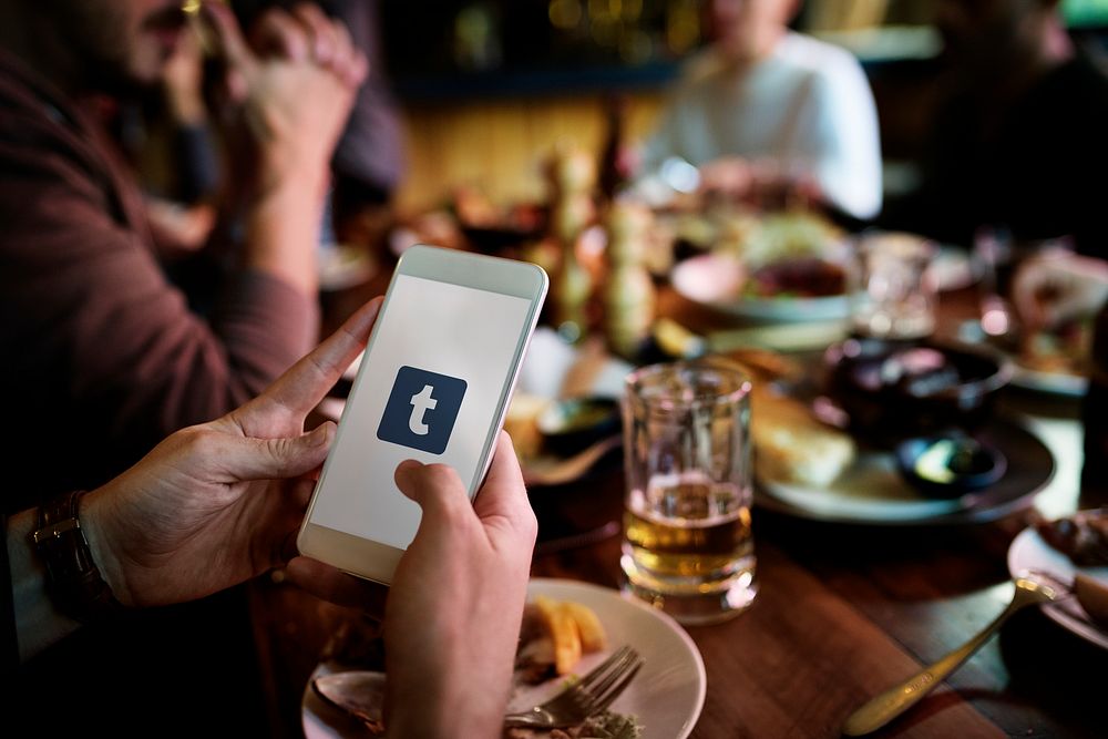 A person using Tumblr application in a restaurant. BANGKOK, THAILAND, 1 NOV 2018.