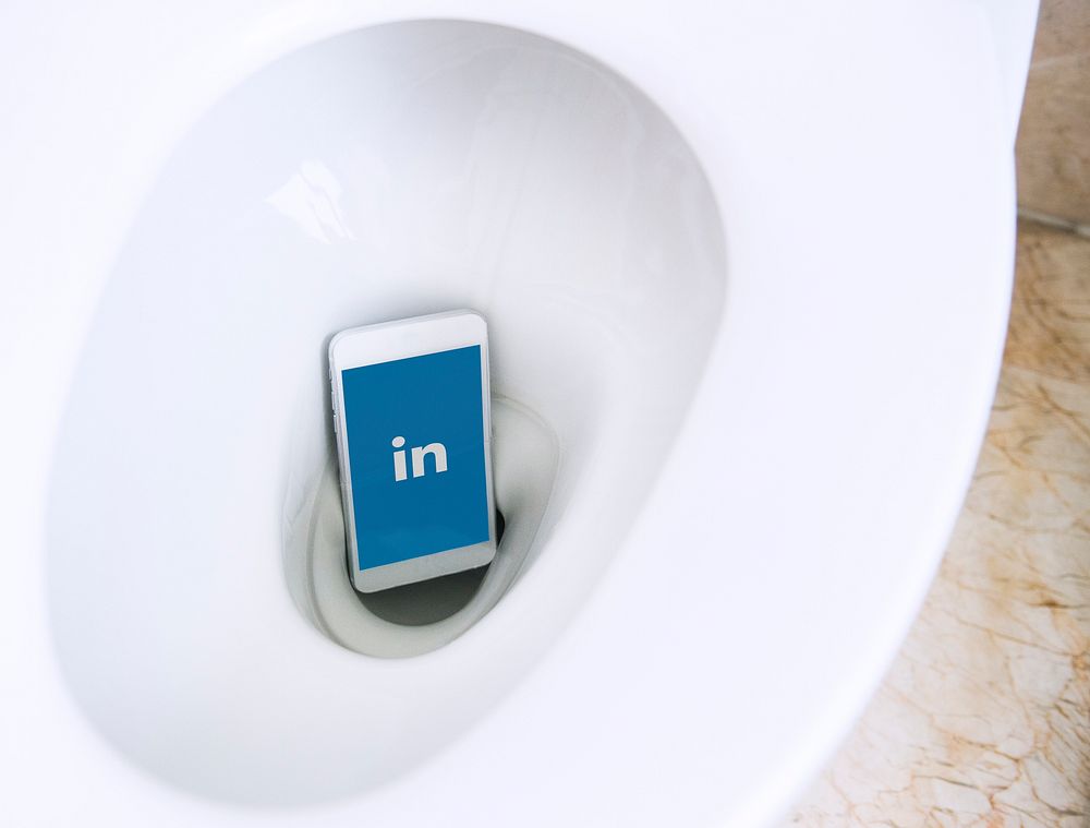 LinkedIn logo showing on a phone placed in a toilet bowl. BANGKOK, THAILAND, 1 NOV 2018.