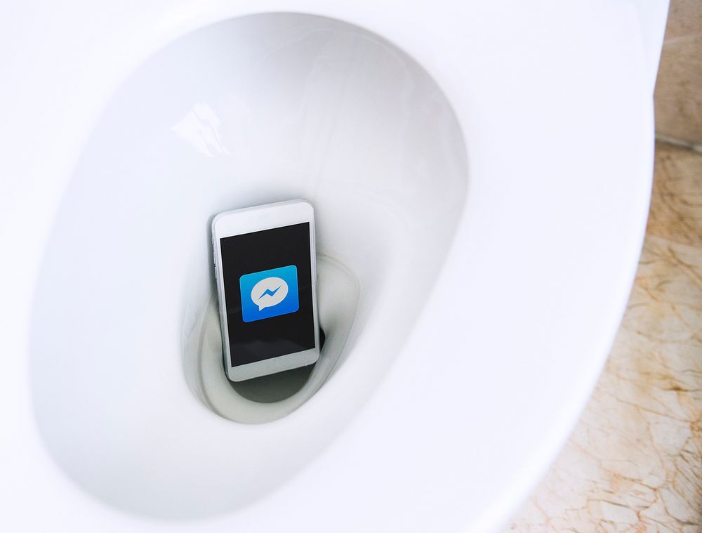 Facebook Messenger application showing on a phone in a toilet bowl. BANGKOK, THAILAND, 1 NOV 2018.