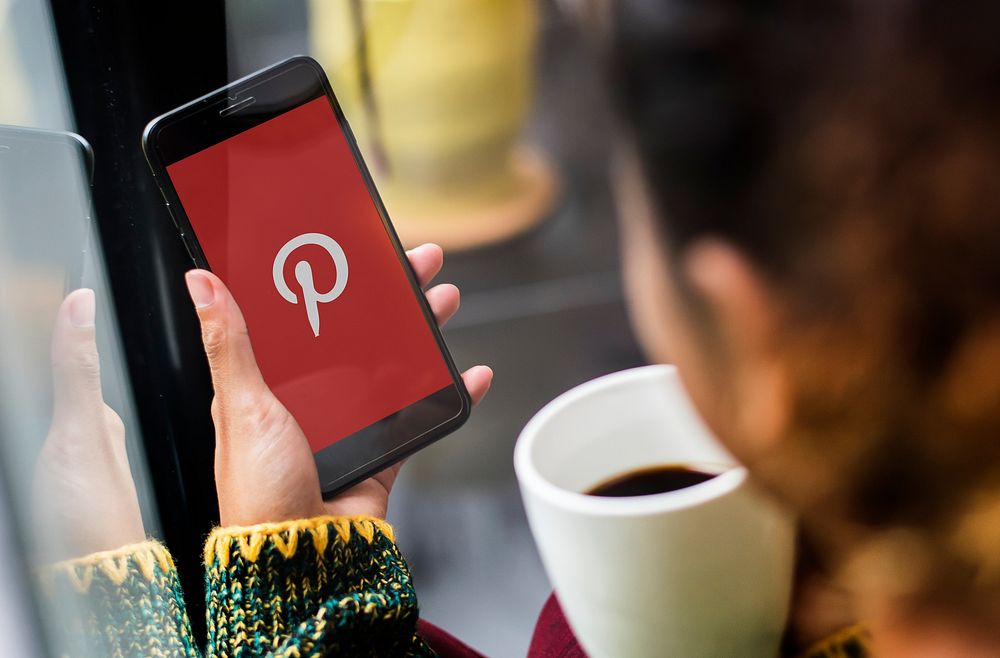 Woman using Pinterest on mobile phone in a cafe. BANGKOK, THAILAND, 1 NOV 2018.