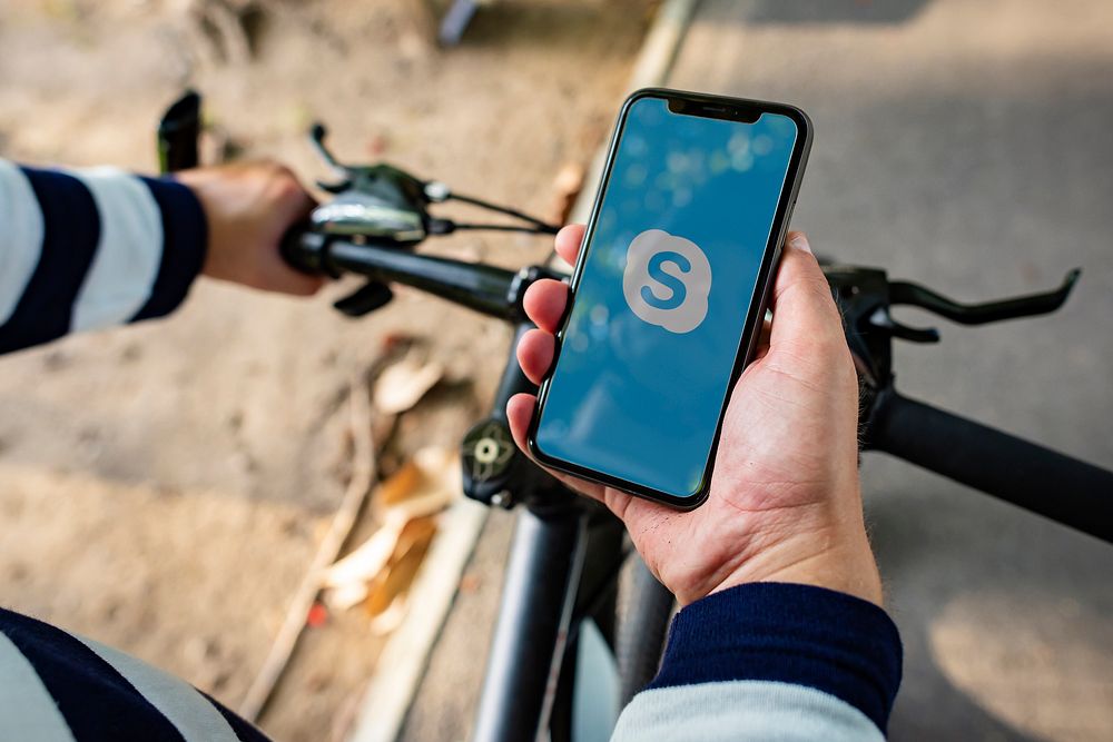 Cyclist using Skype on a phone. BANGKOK, THAILAND, 1 NOV 2018.