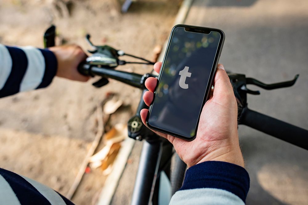 Cyclist using Tumblr on a phone. BANGKOK, THAILAND, 1 NOV 2018.