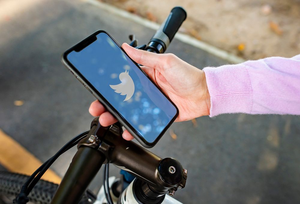 Cyclist using Twitter on a phone. BANGKOK, THAILAND, 1 NOV 2018.