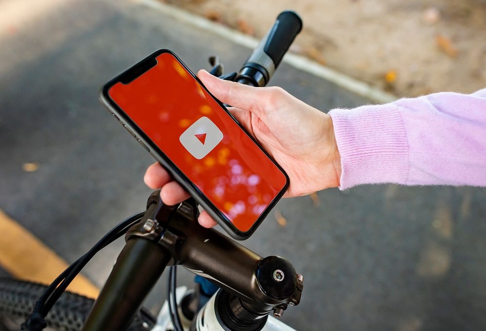 Cyclist using Youtube application on a phone. BANGKOK, THAILAND, 1 NOV 2018.