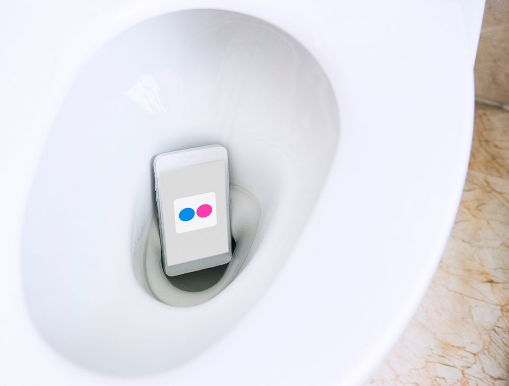 Flickr logo showing on a phone placed in a toilet bowl. BANGKOK, THAILAND, 1 NOV 2018.