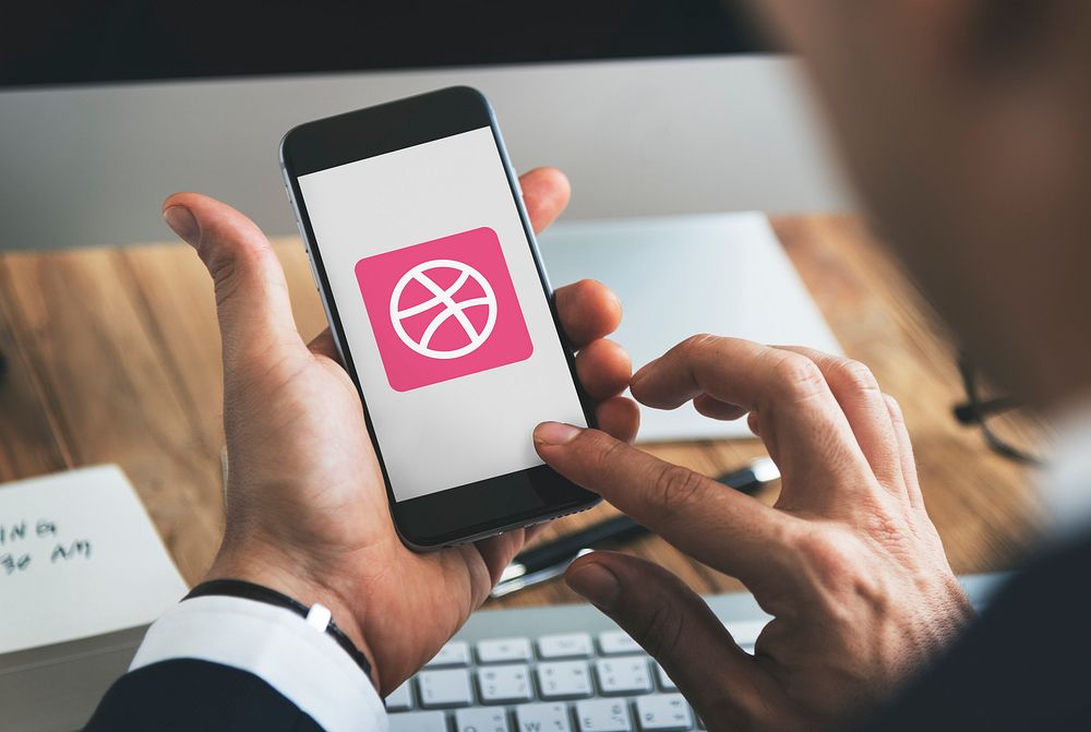 Businessman using Dribbble application in an office. BANGKOK, THAILAND, 1 NOV 2018.