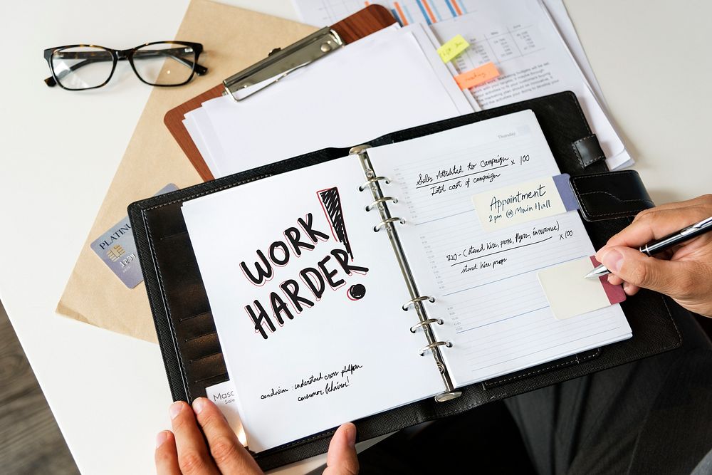 Phrase Work harder written in a notebook