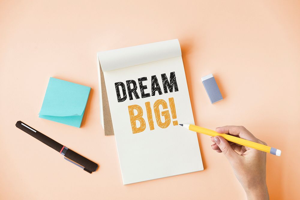 Hand writing Dream big on a notepad