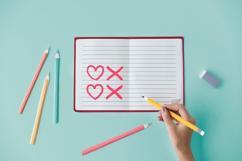 Hand drawing hearts and kisses on a notebook