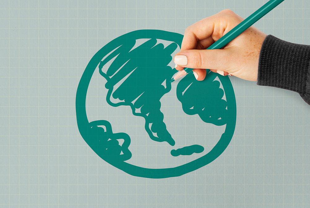 Hand drawing a green globe on a paper