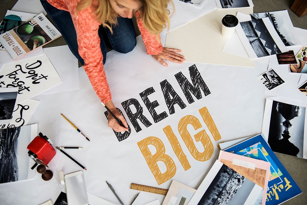 Woman writing Dream big on a paper