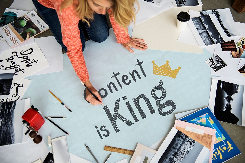 Woman writing Content is king on a paper