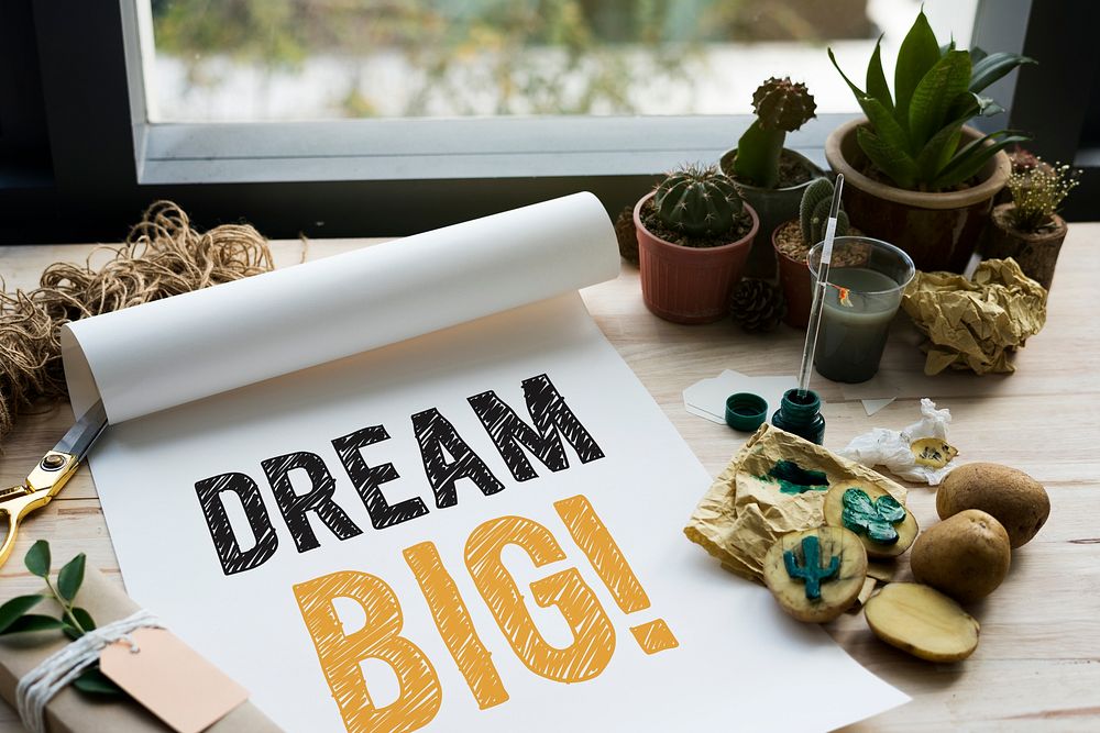 Dream big written on a white paper and cactus