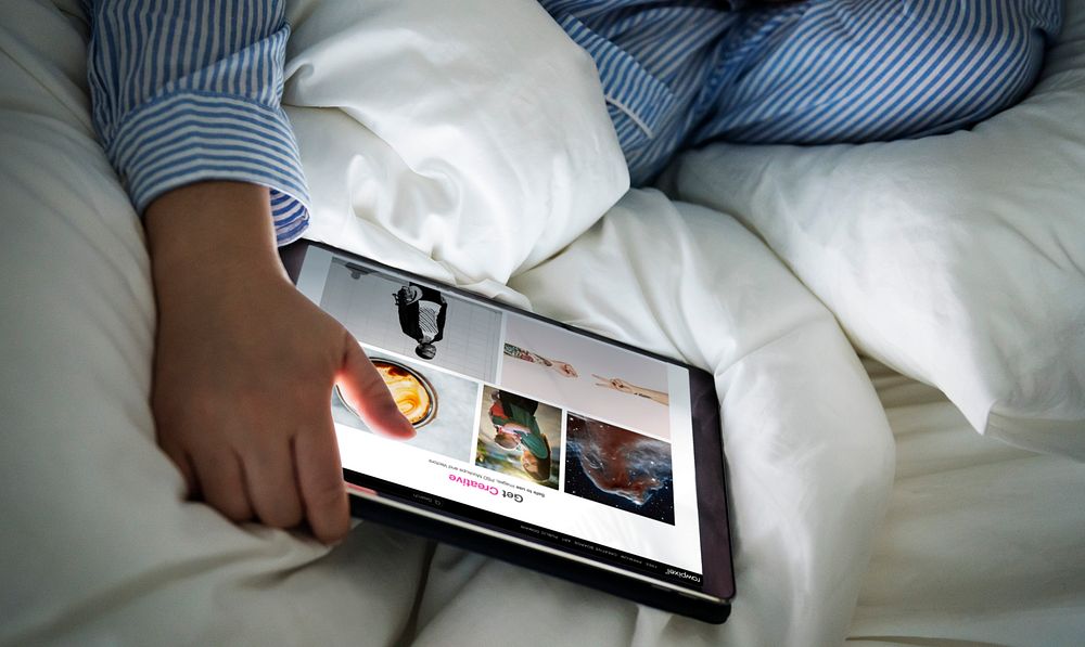 A person using a tablet in bed