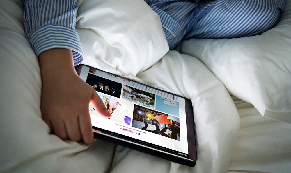 A person using a tablet in bed
