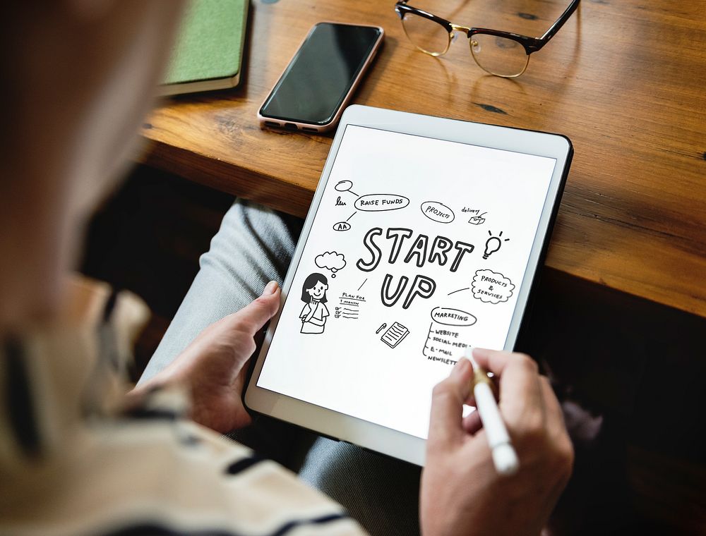 Woman doodling startup ideas on a tablet