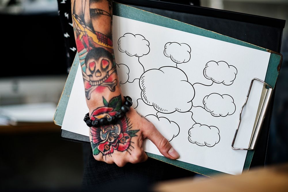 Tattooed hand holding an empty cloud clipboard