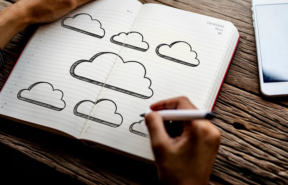 Man drawing clouds in a notebook