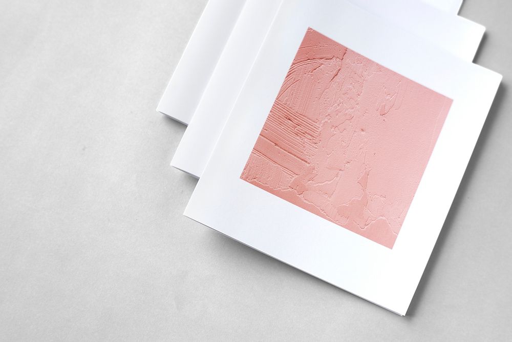Brochures with pink texture imagery on a gray background