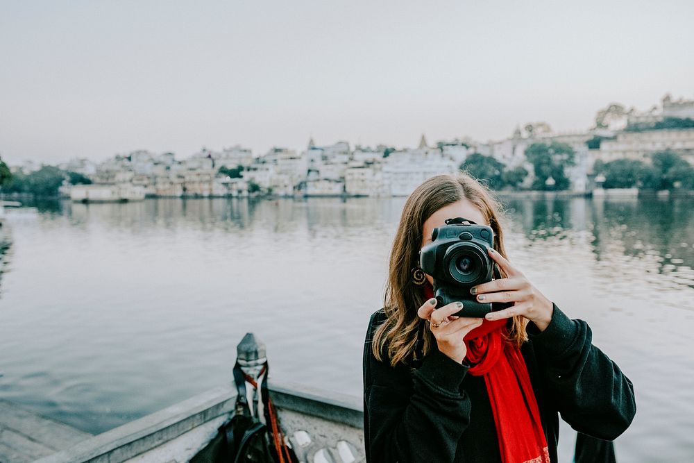 Travel wallpaper background wanderlust woman capturing a city view of Udaipur, India, vintage tone