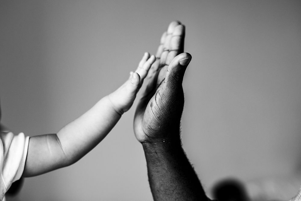 Black and white wallpaper background, kid giving high five to adult