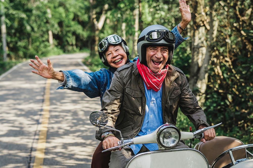Senior couple enjoying scooter ride, vivid tone