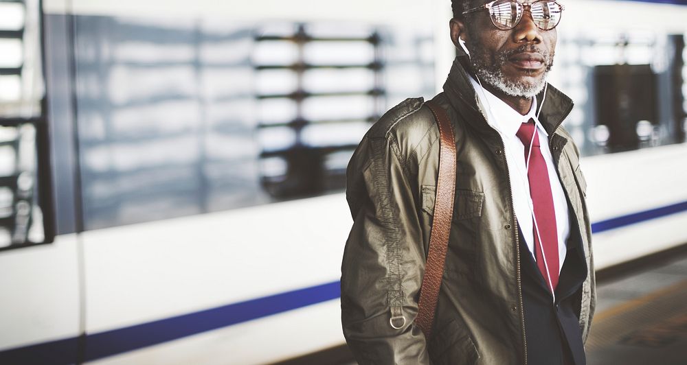 African descent businessman is using earphones