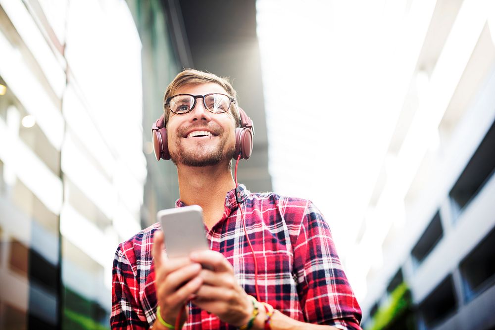 Man using mobile phone listening music wearing headphones