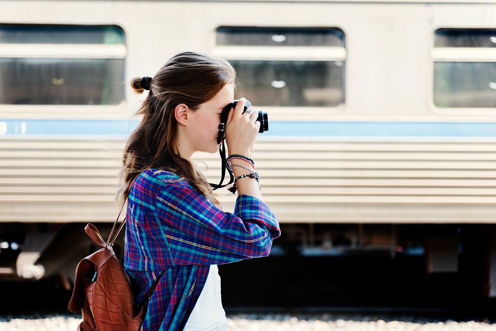 Young woman is taking photo with film camera