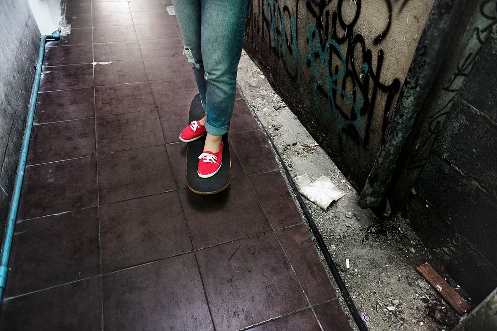 Person standing on skateboard in streetside alley