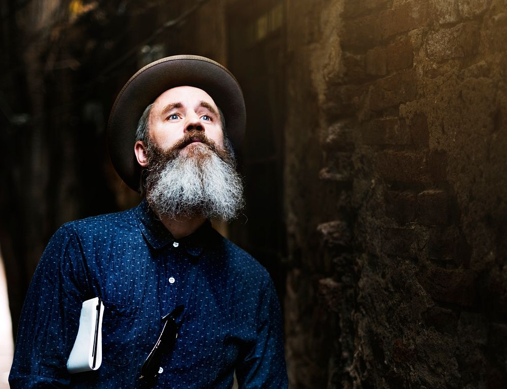 A bearded man walking through an alley