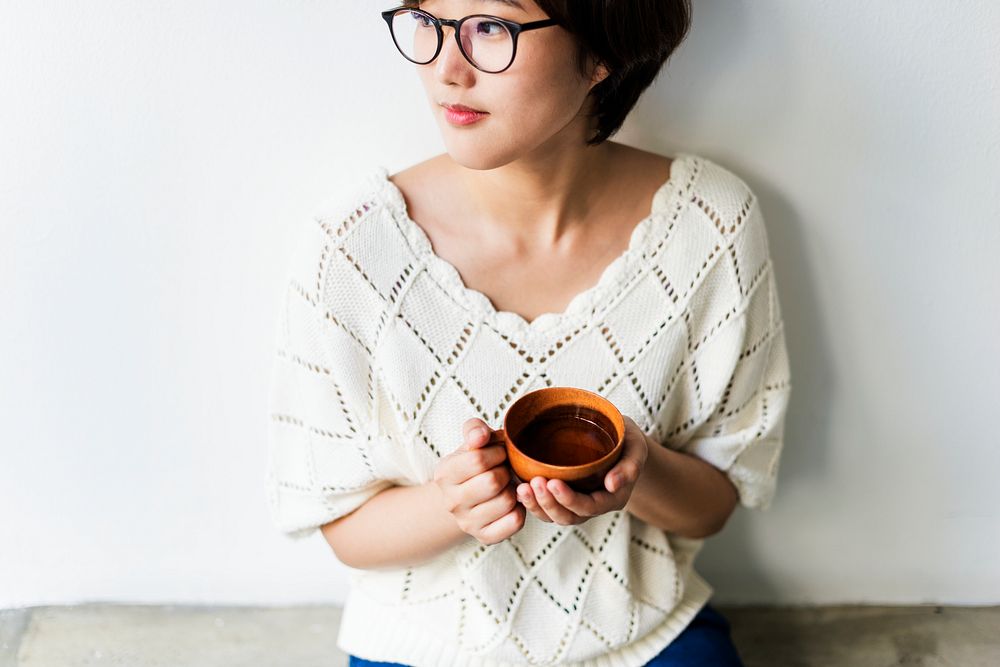 An Asian woman enjoying her cup of tea