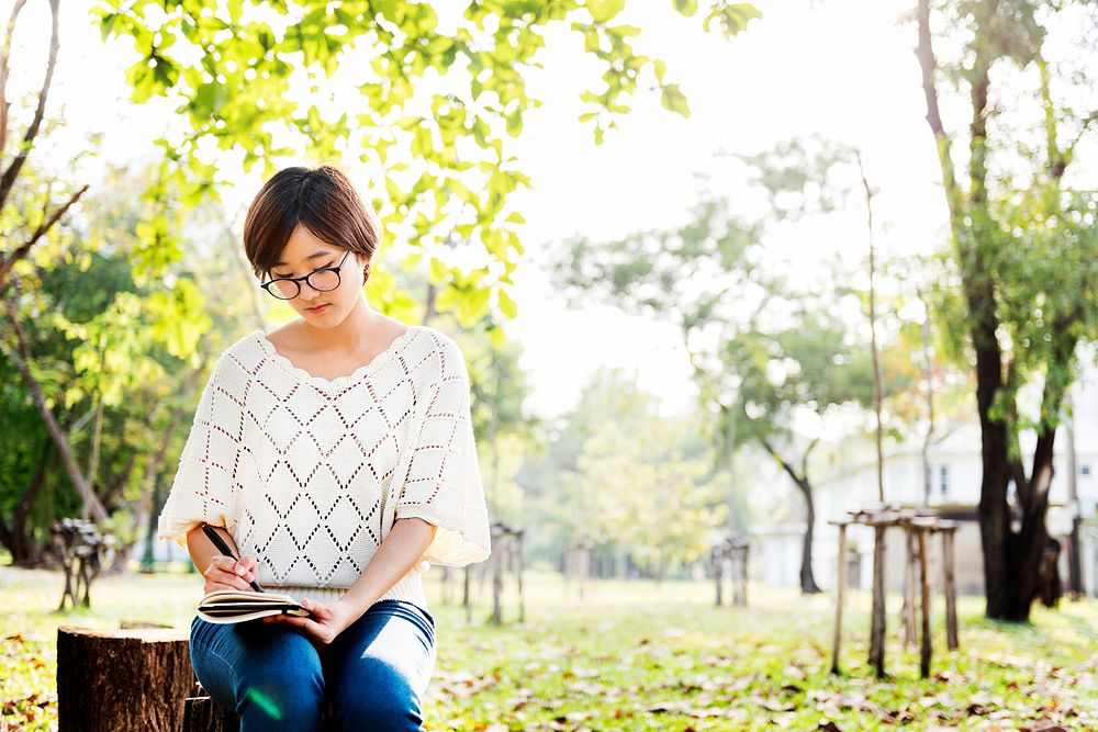Young Woman Sitting Writing Outside Concept