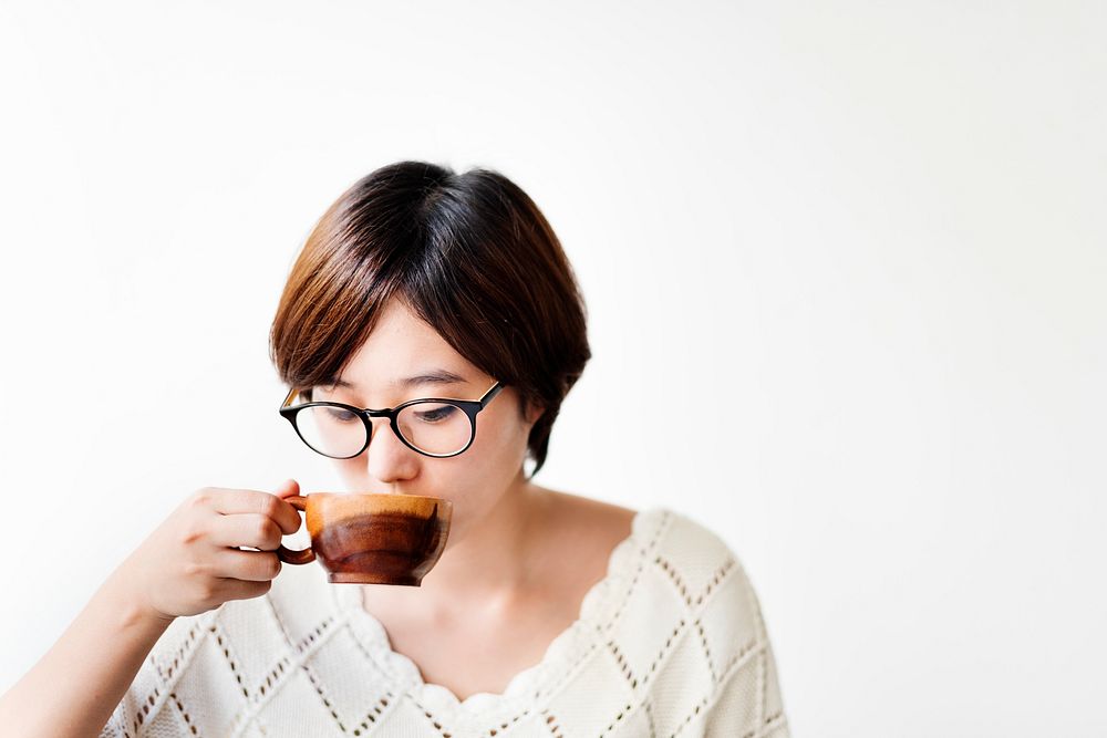 Asian woman drinking coffee with wooden cup
