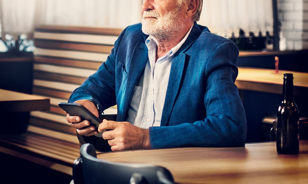 Elderly man is sitting in a pub