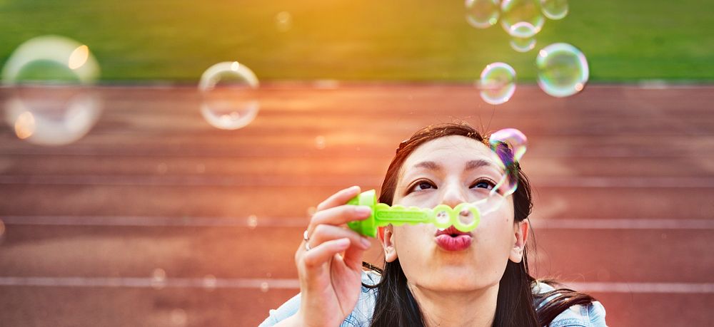 Asian woman blowing soap bubbles