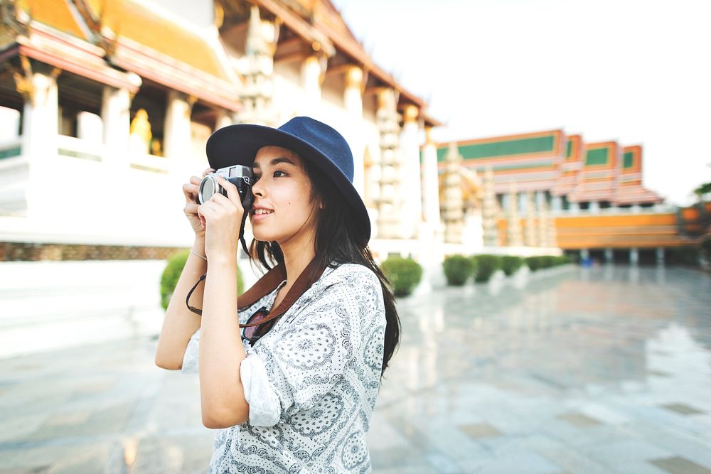 Young woman taking photo by film camera