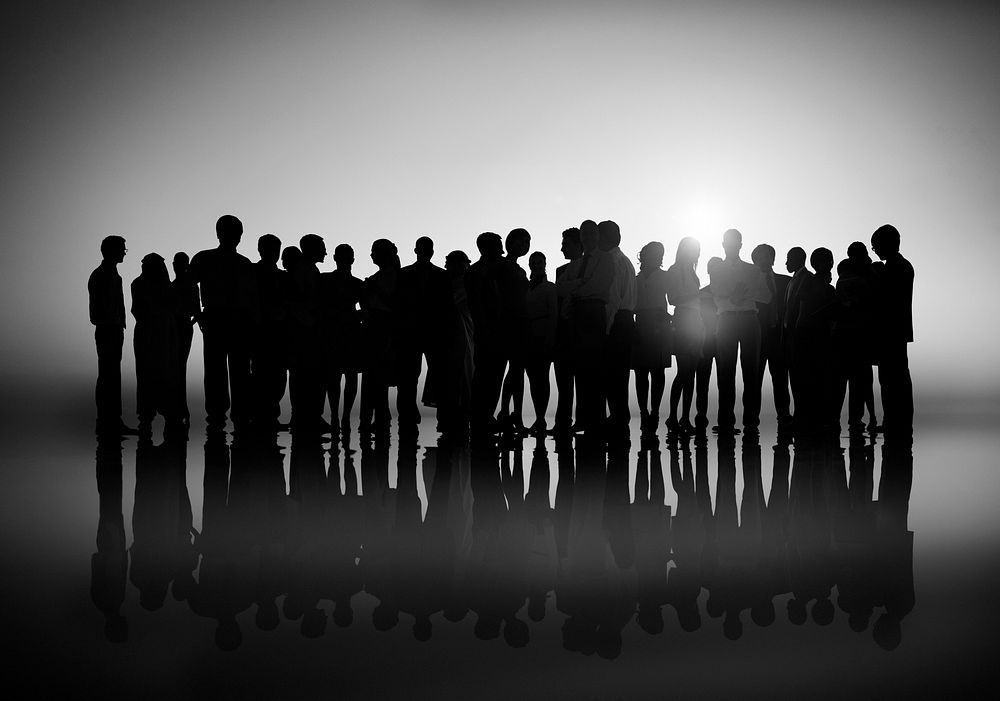 Group of business people together in a setting sun.