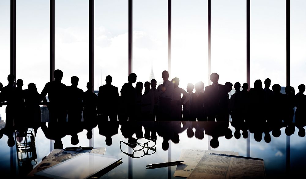 Silhouetts of group of business people standing and posing near the window.